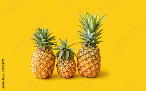 Three pineapples represent a family in on a yellow background. Space for text