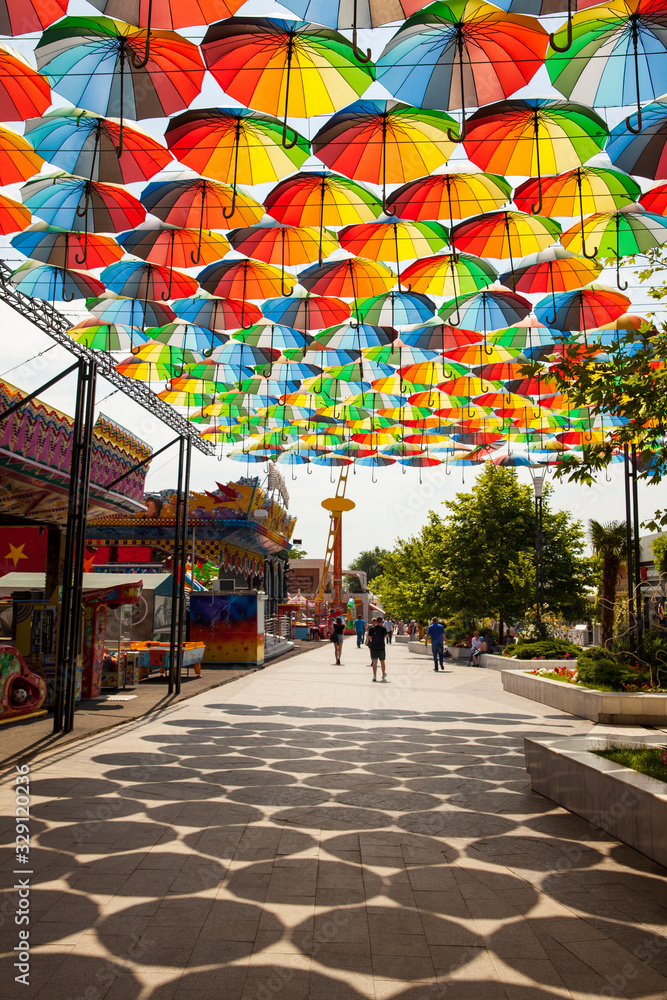 Fototapeta premium Street decorated with colorful umbrellas. Colorful umbrellas in the sky. Street decoration