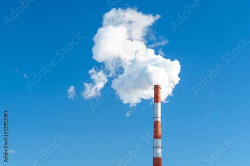 industrial smoke from a chimney in the blue sky. space for text, copy space