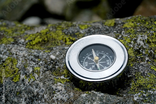 Silver compass on a rock in the mountains, High Tatras, Orienteering in the mountains 