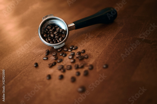 Fototapeta Naklejka Na Ścianę i Meble -  Flat lay of fresh roasted coffee beans prepared in portafilter for espresso machine.component of the espresso maker