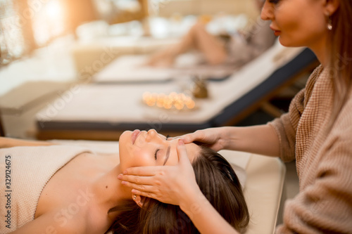 pretty caucasian woman came to get recreational massage on face, in spa salon. lady with closed eyes, lying on bed on her back. healthy lifestyle concept