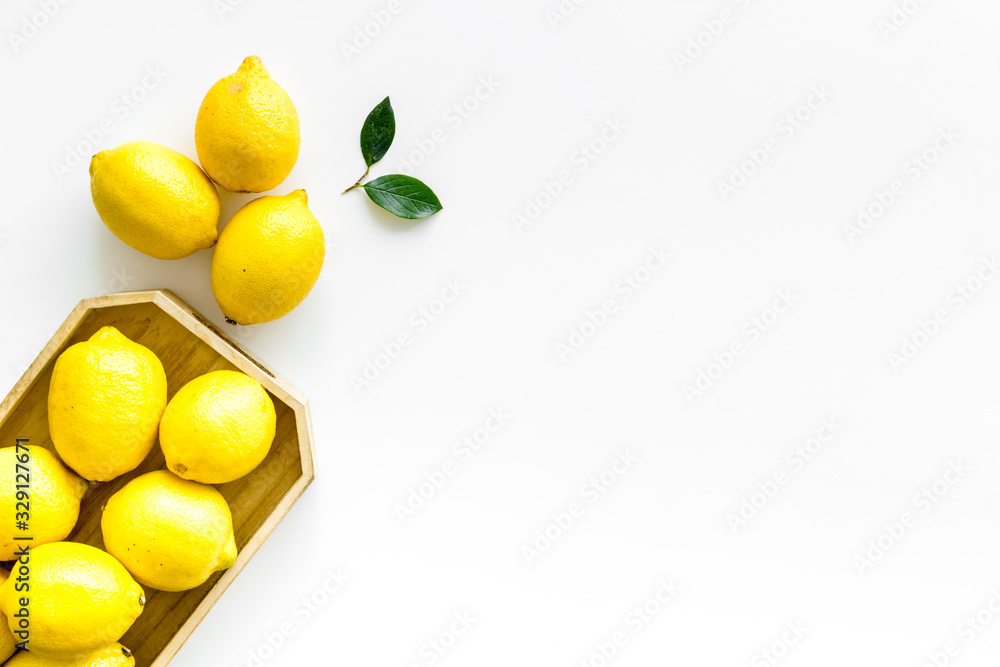 Ripe lemons in tray on white backgroud top-down frame copy space