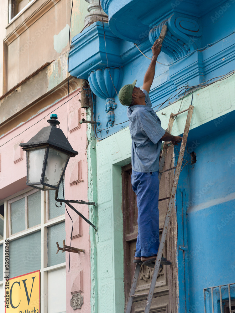 Man cleaning the wall of a house, Havana, Cuba