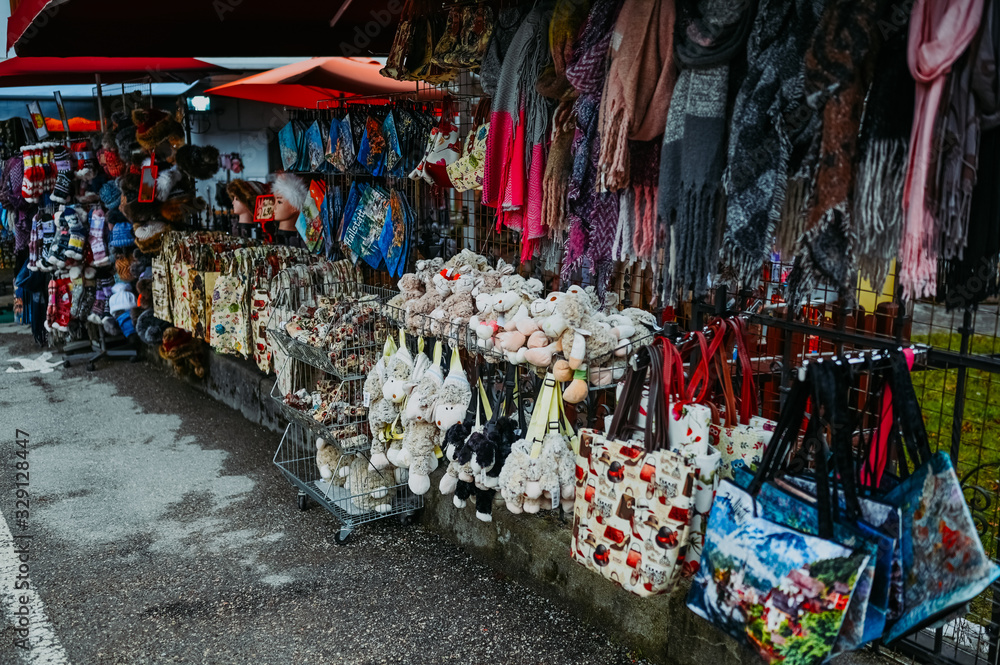 Souvenir shop with traditional postcards, magnets, bags, scarves, socks at the historic area of the mountain village Hallstatt. Austria. Unesco. Salzkammergut region. Travel and touristic concept