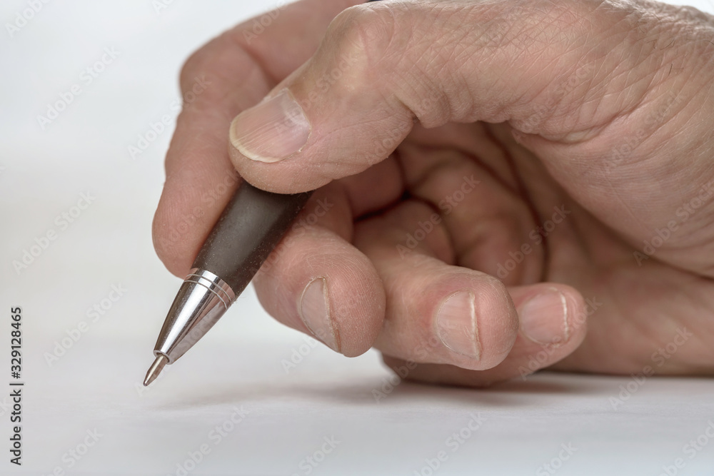 senior person writes on blank paper with ball pen at table senior person writes on blank paper with ball pen at table