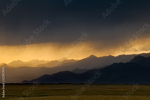 Kyrgyzstan. The sun rays at sunset break through the gloomy rainy clouds © Александр Катаржин