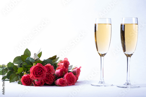 lush bouquet of red roses and champagne on a table