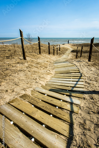 Spring sun illuminates the path over the dunes to Lake Michigan at Kohler Andrae State Park, Wisconsin photo