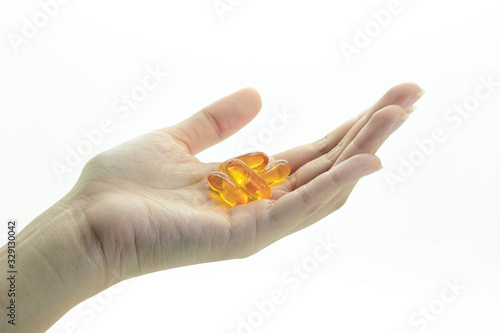Close up hand holding fish oil tablets on isolated white background