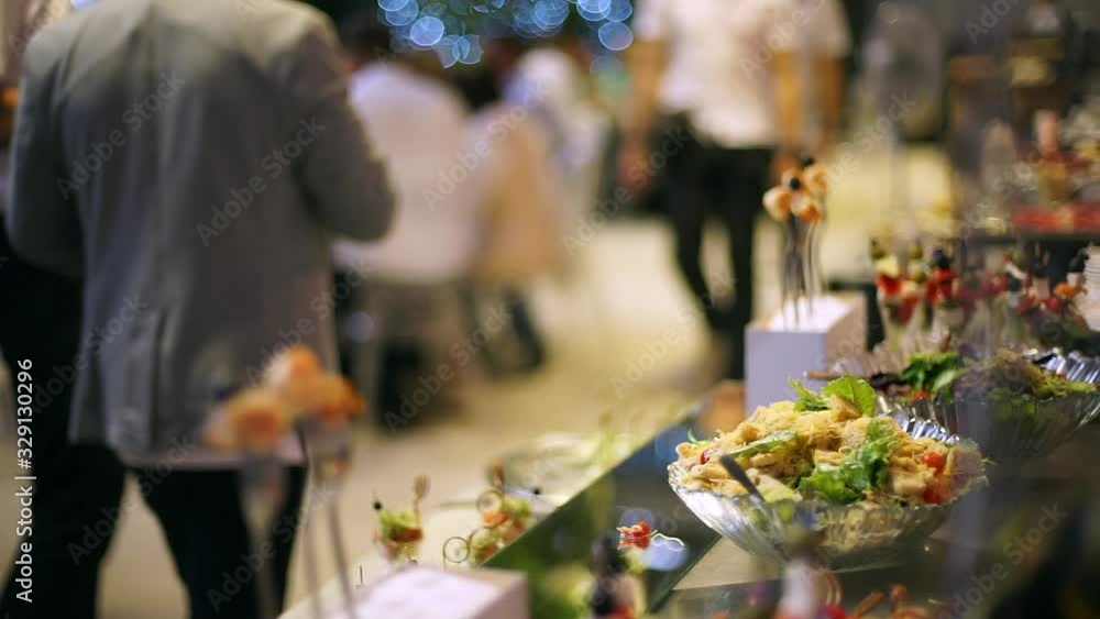 Guest puts food on a plate, a beautiful table. A table with catering, beautiful dishes and snacks, desserts, fruits. Guest puts food on a plate, a beautiful table. A table with catering, beautiful dishes and snacks, desserts, fruits.