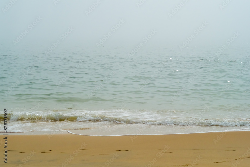 Green Sea Waves on a Yellow Beach in Spain in a Foggy Day