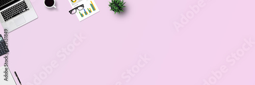 Top view office desk and supplies, with copy space. Creative flat lay photo of workspace desk/Panoramic banner isolated on pink background