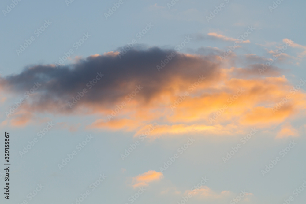 isolated yellow cloud cumulus (stratocumulus) cloud in a warm sky