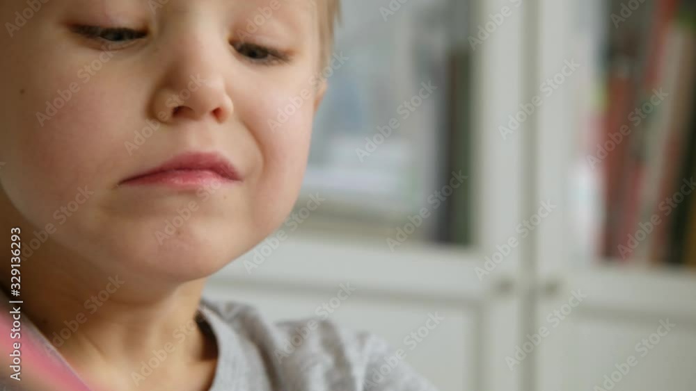 Preschool boy toddler, holding pencil, drawing or doing homework at the table. Close up Preschool boy toddler, holding pencil, drawing or doing homework at the table. Close up