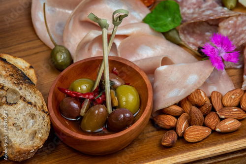 Close up of italian antipasti on plate. Italian antipasti wine snacks set. Cheese variety, Mediterranean olives, pickles, Prosciutto di Parma, nuts and other appetizers