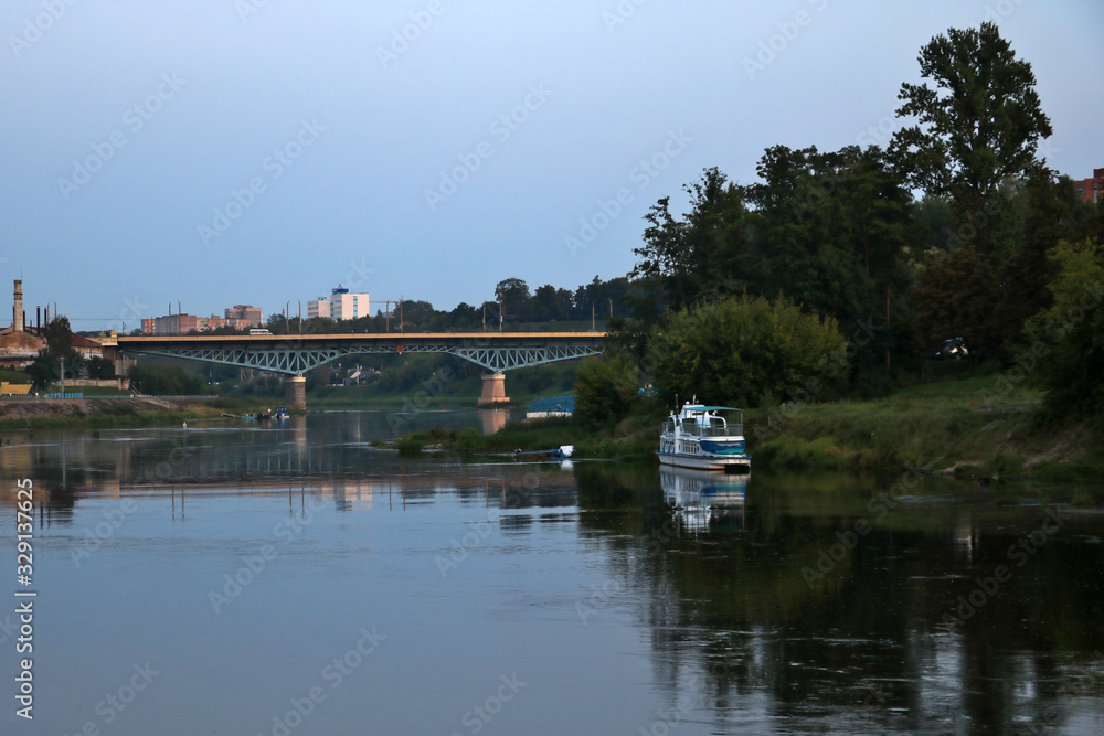 View of the wide Neman river over the bridge in the evening.