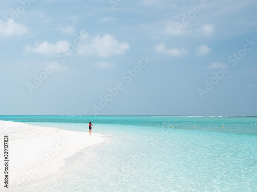 Beautiful Young Woman Run on the Maldivian Beach.