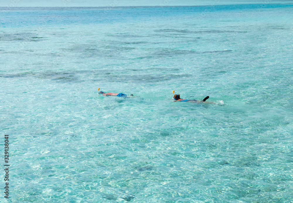 Pair of Snorkeler in Turquoise Maldivian Waters.
