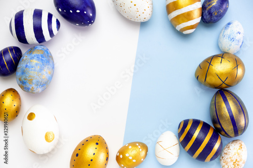 Happy Easter. Frame for text made of easter eggs trendy colored classic blue, white and golden on blue. Minimal style, top view, flatlay, copy space photo