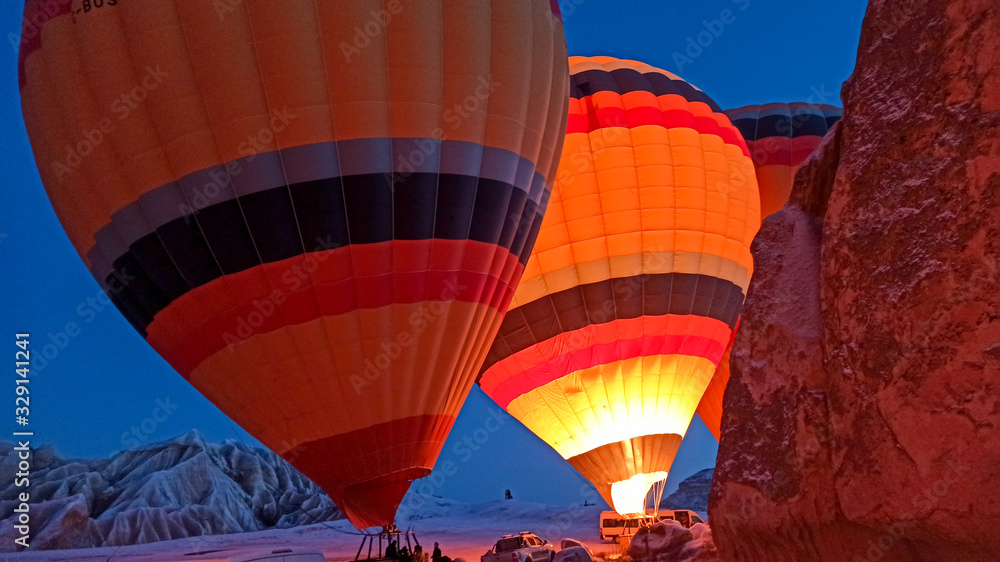 Obraz premium Hot air balloons preparing to fly at early morning in winter season in Cappadocia, Turkey