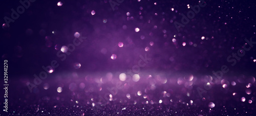background of abstract glitter lights. black and purple. de focused