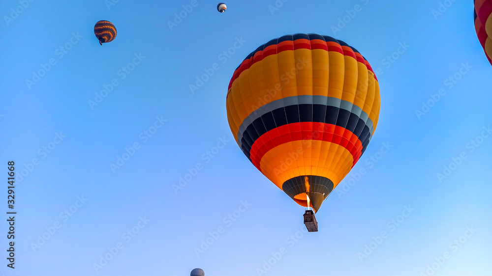 Colorful hot air balloons flying over the valley with fairy chimneys in winter season. Lots of Hot air balloons at the sunrise sky landscape in Cappadocia, Turkey Colorful hot air balloons flying over the valley with fairy chimneys in winter season. Lots of Hot air balloons at the sunrise sky landscape in Cappadocia, Turkey