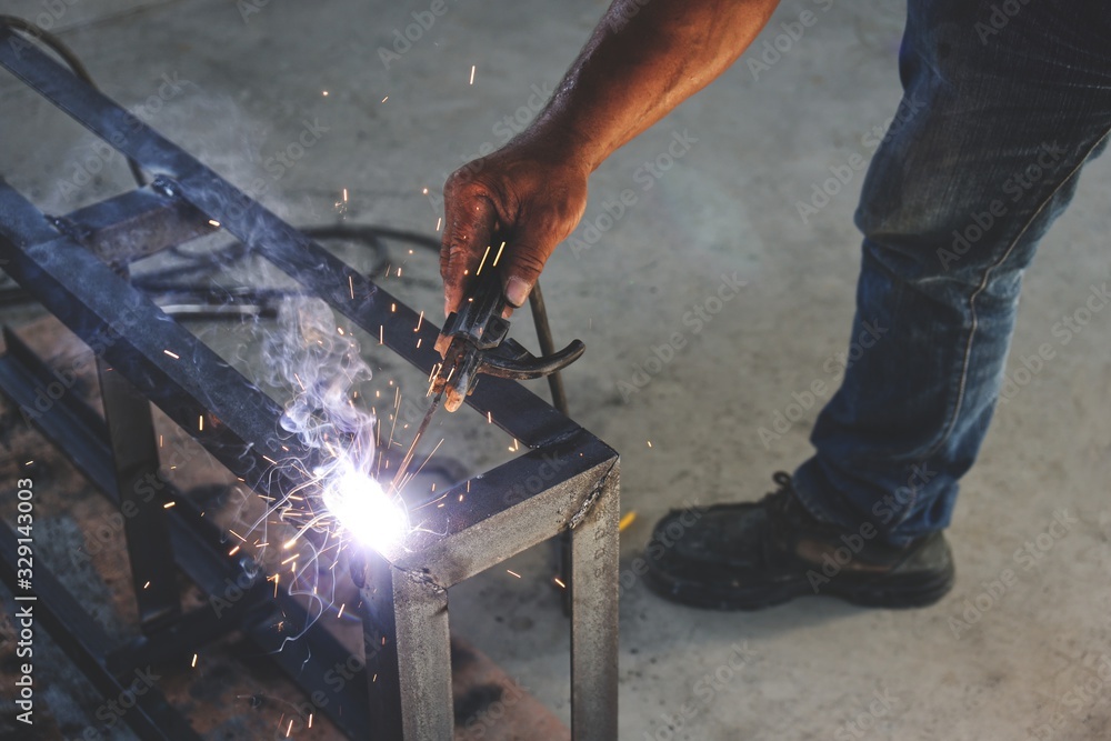 Workers are welding steel without protective gloves. Workers are welding steel without protective gloves.