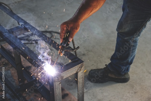 Workers are welding steel without protective gloves.