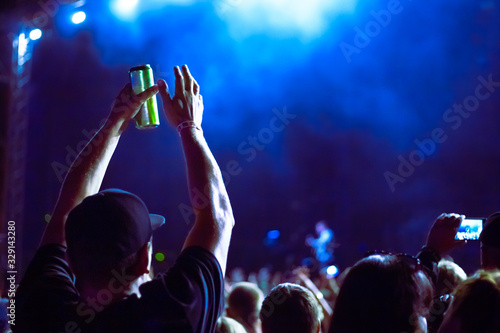 man holds a can of beer and claps his hands