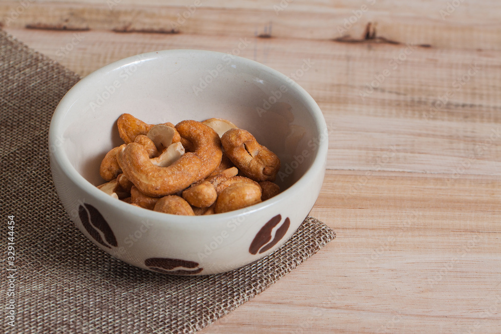 Fototapeta premium Dried Cashew Nuts food snack organic nut with salted in the little white bowl on wood background table 