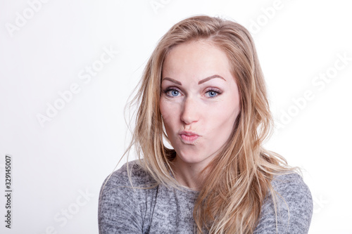 portrait of a blond young woman pursing lips