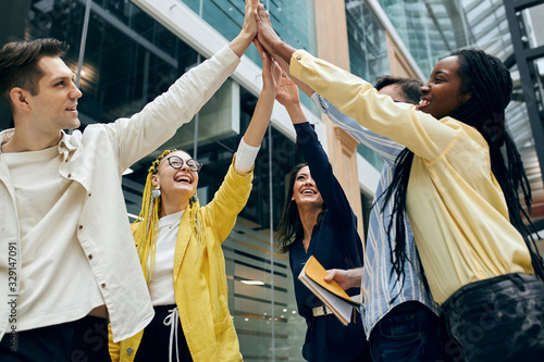 фотографія smiling axcited colleagues holding hands, arms together, begging , promising to