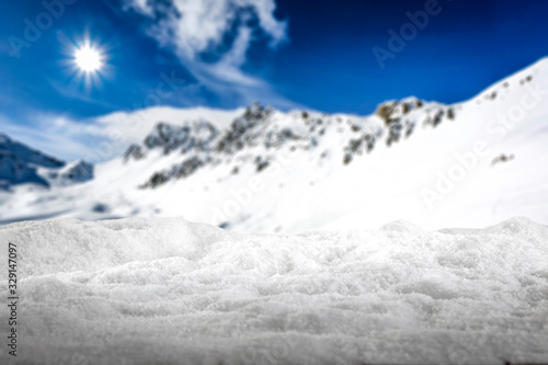 White wooden desk cover of white snow and free space for your decoration.Mountains in Alps and sunny cold day. 