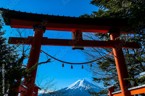 Distant view on Mt Fuji, framed in between orange Torri gate, leading to Chureito Pagoda in Japan, on a clear, wintery day.The top parts of the volcano are covered with a layer of snow. Holly mountain © Chris