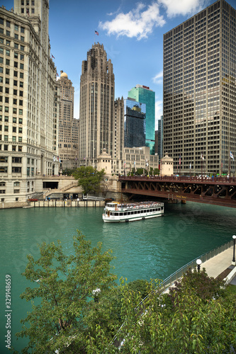 Ferry boat passes under the DuSable Bridge over the Chicago River in downtown Chicago Illinois USA during a summer day photo