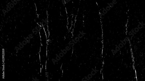 Heavy drizzle, rain water droplets slowly trickling down the window pane at night