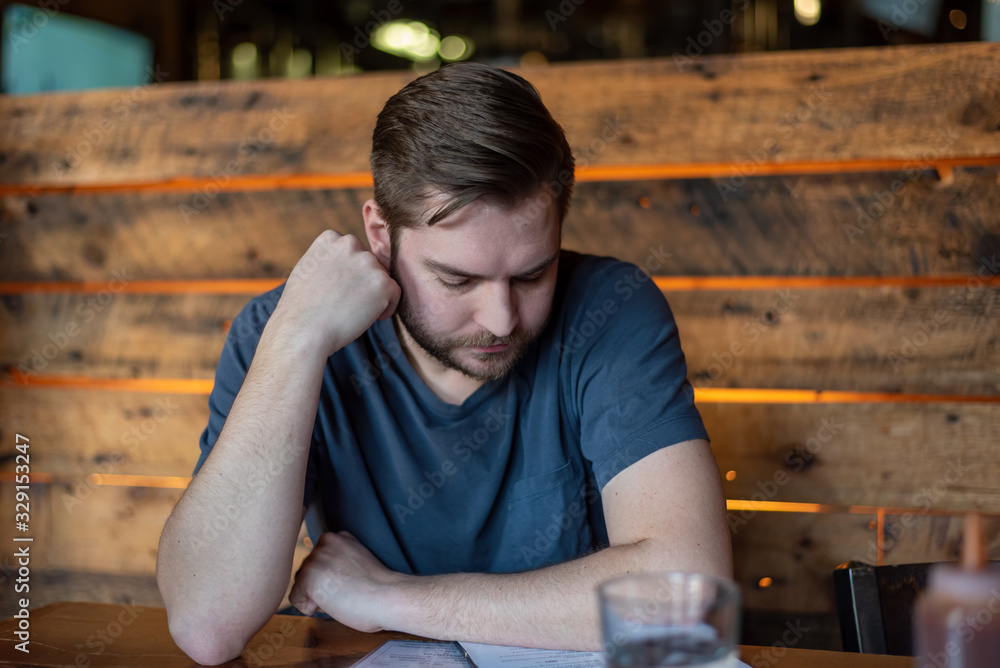 Obraz premium Young man looking at a menu at a craft brewery