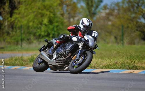 Road racing motorcykel in high speed into a curve  panning shot