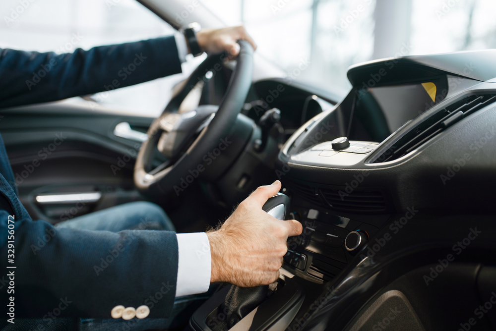 Man behind the wheel of automobile, car dealership