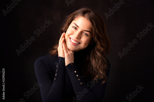 Attractive young woman portrait at isolated dark background