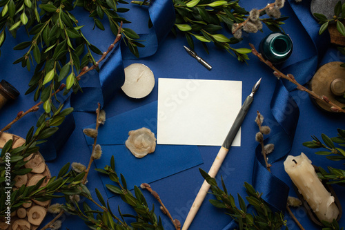 Mockup with postcard and woodbox on classic blue background. card and leaves. ink pen, ink, stamp.  photo