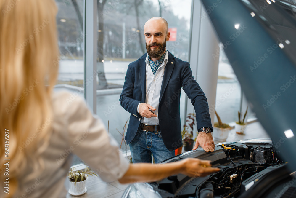 Man and saleslady choosing auto in car dealership Man and saleslady choosing auto in car dealership