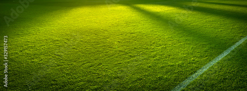 Side lines panorama of an empty green sports field before a game
