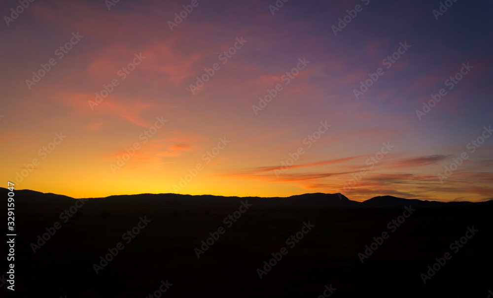 Purple sunset sky background. Blue, pink, red sunrise colors. Beautiful yellow, orange evening clouds. Colorful night twilight scene.