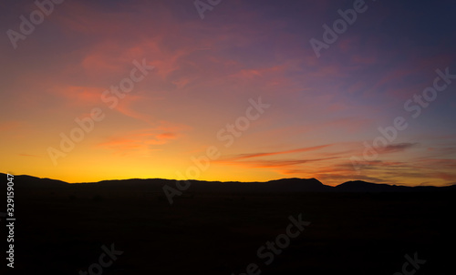 Purple sunset sky background. Blue, pink, red sunrise colors. Beautiful yellow, orange evening clouds. Colorful night twilight scene.