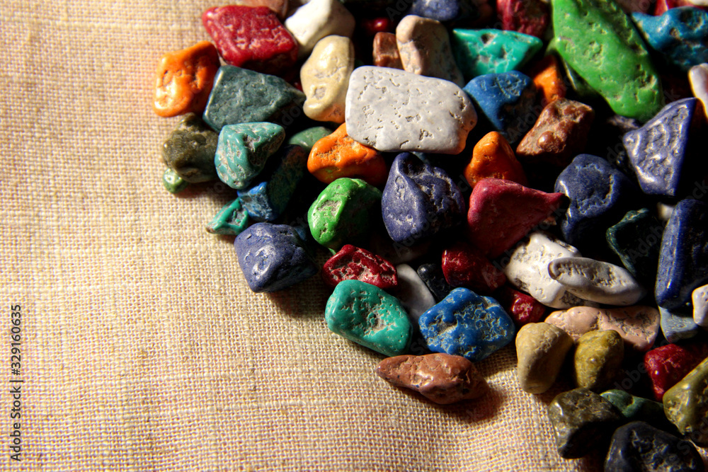 Sweet stones on the right on a beige background. Green, orange, pink, white candies. Sweet stones on the right on a beige background. Green, orange, pink, white candies.