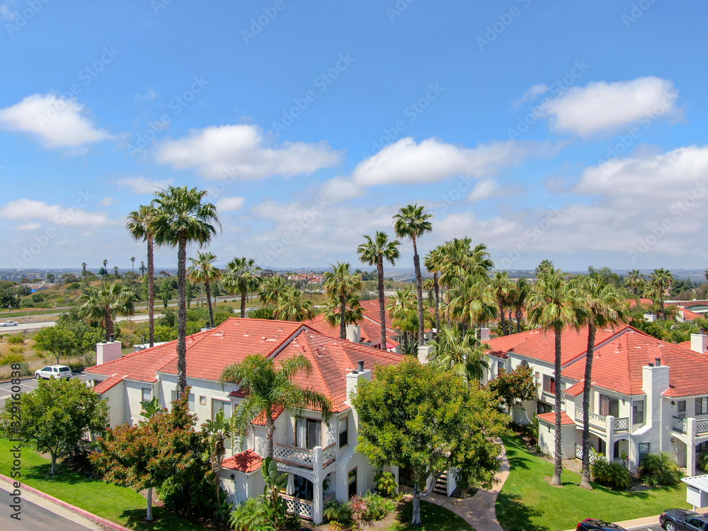 Aerial view of typical Southern California Spanish style residential condo, surrounded by nice garden with palm trees. San Diego, California, USA