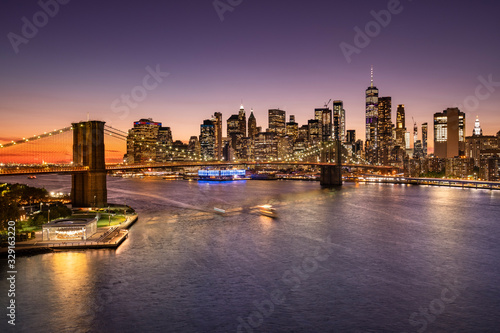 Brooklyn Bridge over the East River and the Manhattan downtown city skyline at night in New York USA photo