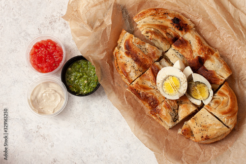 Homemade burek with cheese and spinach and boiled egg.Traditional food photo